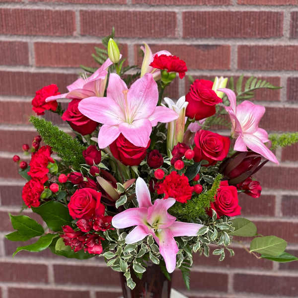 Pink lilies and red roses in a glass vase