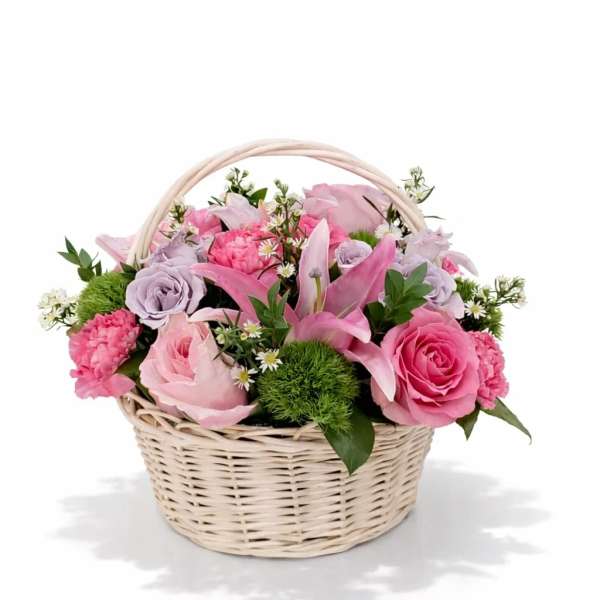 Pink and lavender flowers arranged in a wicker basket