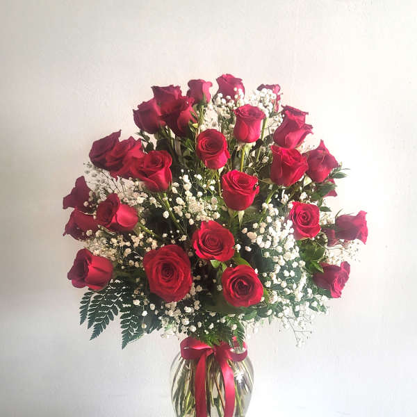 Bouquet of red roses with baby's breath in a glass vase