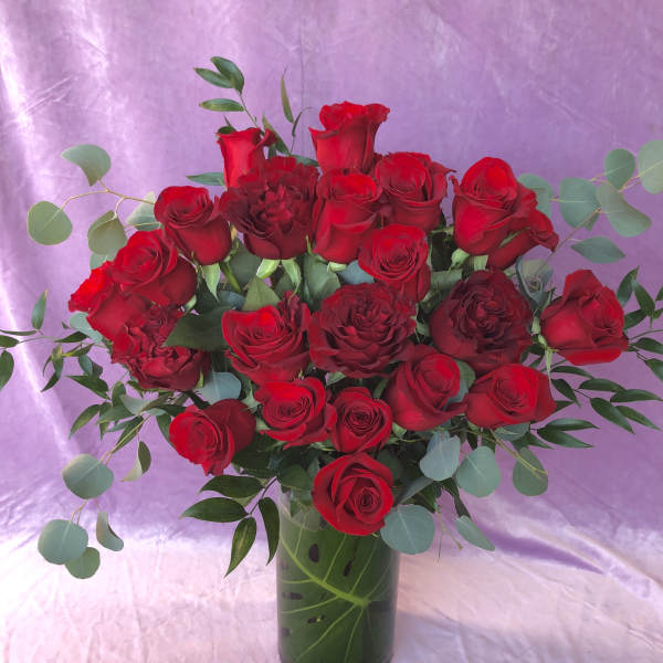 Bouquet of red roses in a glass vase with eucalyptus