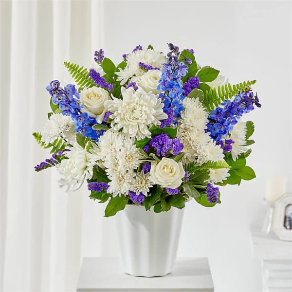 White and purple flower arrangement in a white vase