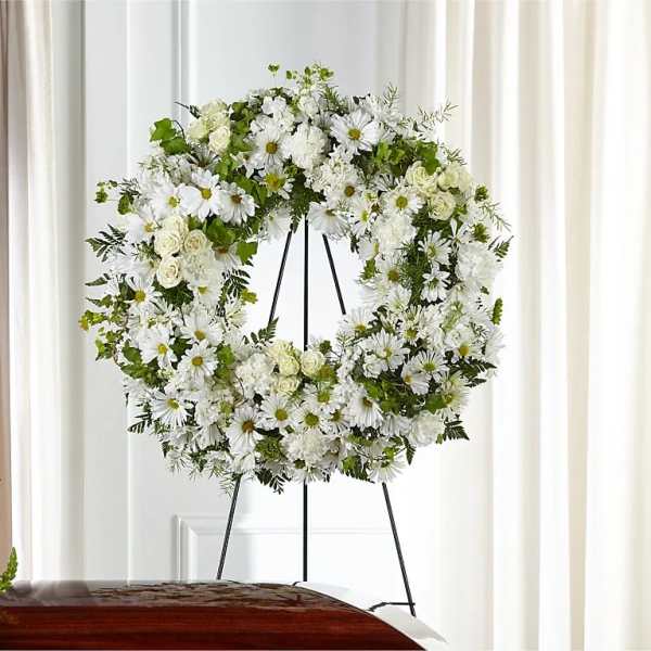 White floral wreath on a black stand