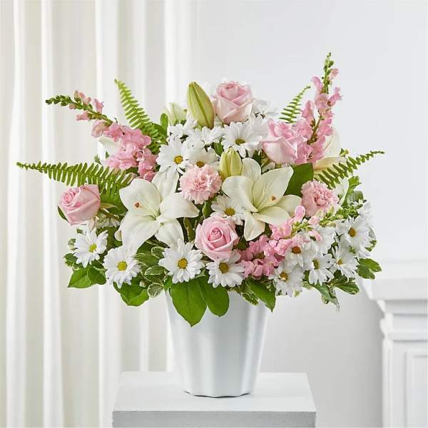 Pink roses and white lilies in a white vase