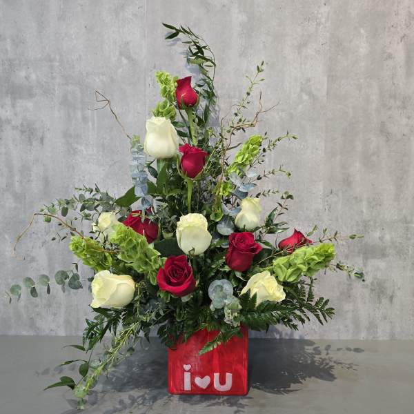 Red and white roses arranged in a red vase with "i love u" text