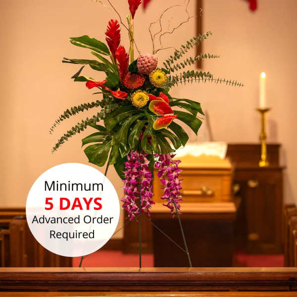 Tall tropical standing spray with red and purple flowers on an easel in a church