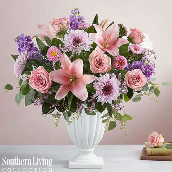 Pink and purple floral arrangement in a white vase