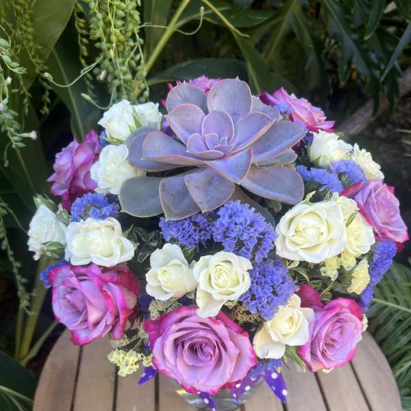 Bouquet of pink and white roses with a purple succulent centerpiece