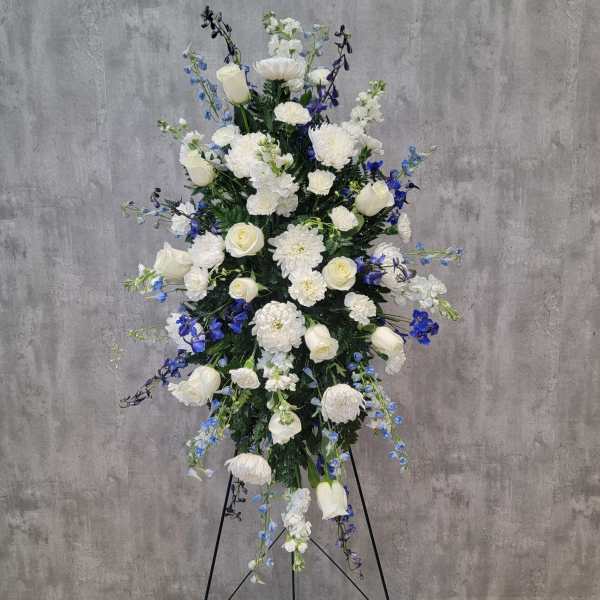 Tall white and blue floral standing spray on an easel