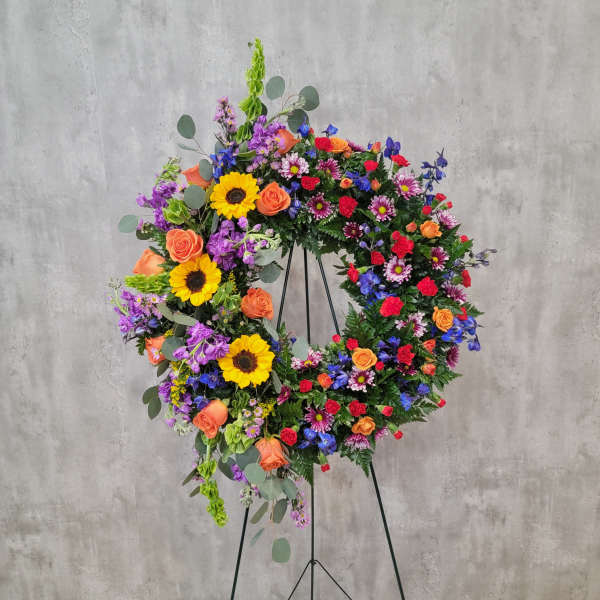 Large colorful floral wreath on a black stand