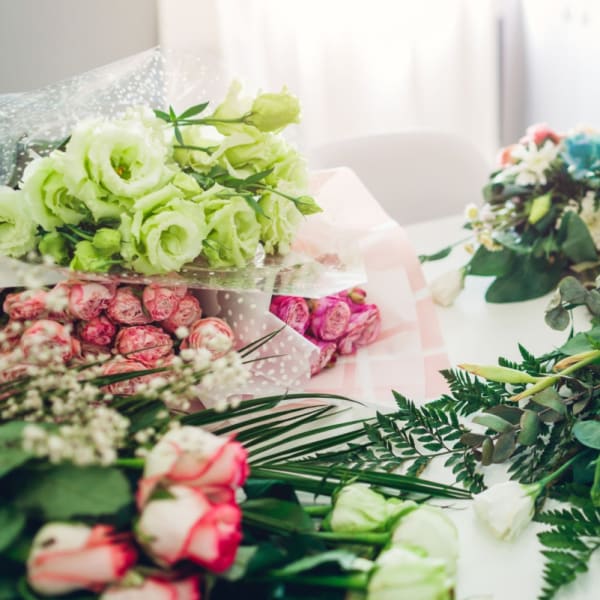 Assorted bouquets of roses and white flowers on a table