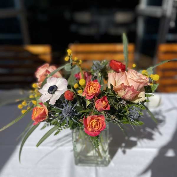 Mixed bouquet of roses and anemones in a clear glass vase