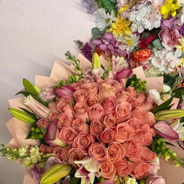 Bouquet of pink roses and lilies wrapped in blush paper