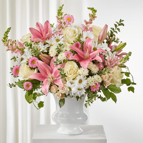Pink lilies and cream roses in a white vase