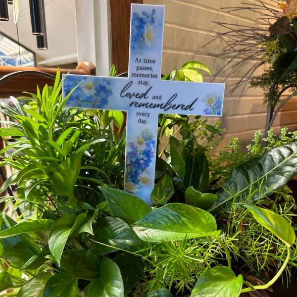Green potted plant arrangement with a memorial cross sign