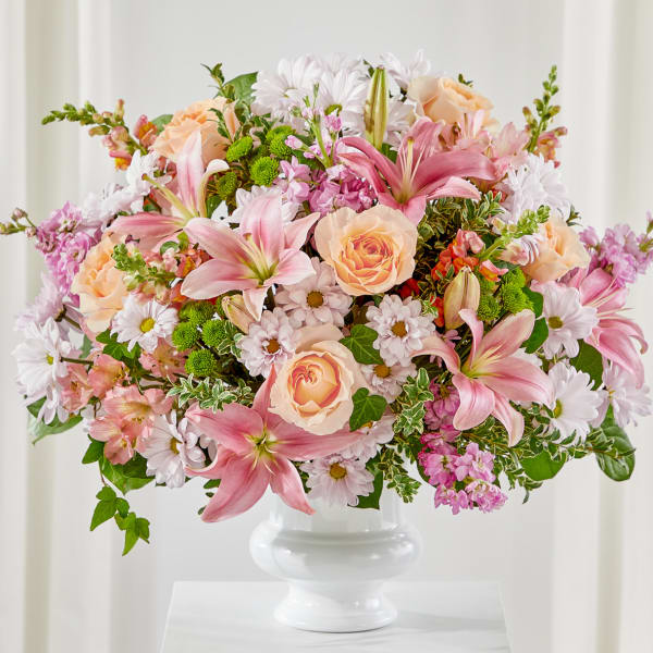 Pink lilies and peach roses in a white vase