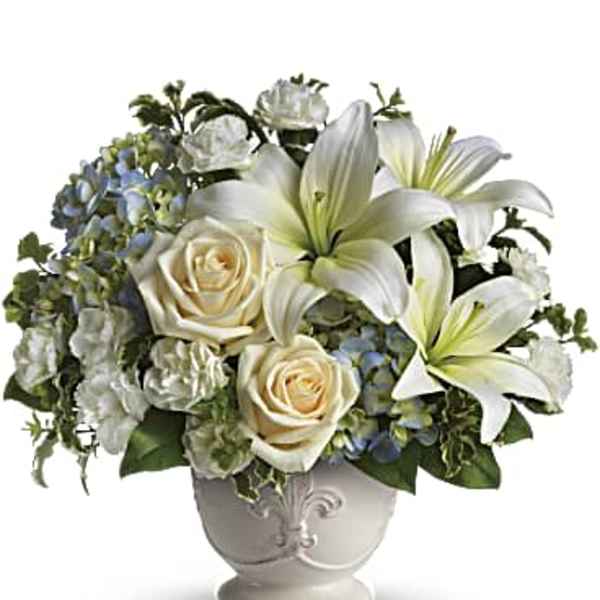 White lilies and cream roses in a decorative vase