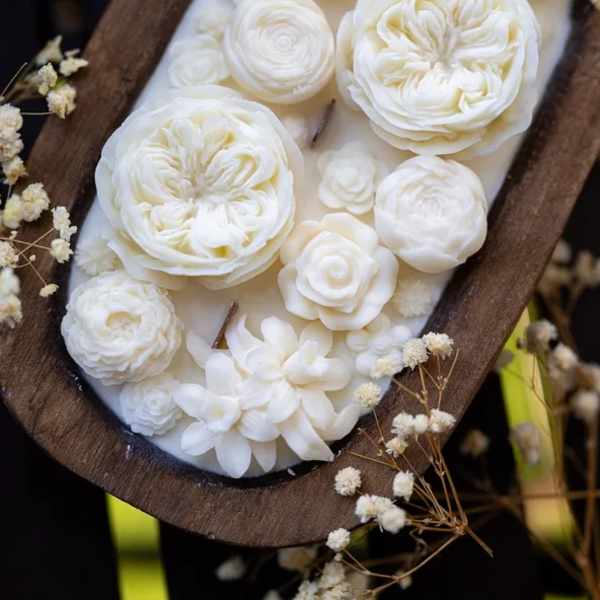 White floral arrangement in a wooden oval tray with small filler flowers