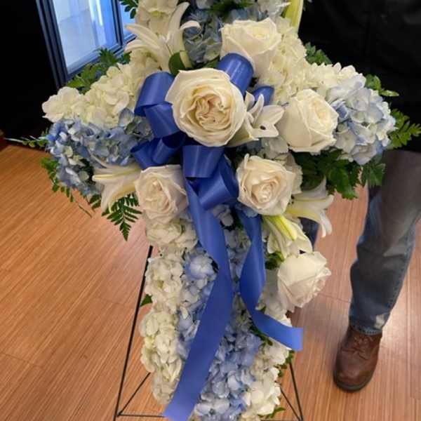 Tall white and blue floral standing spray with roses and lilies