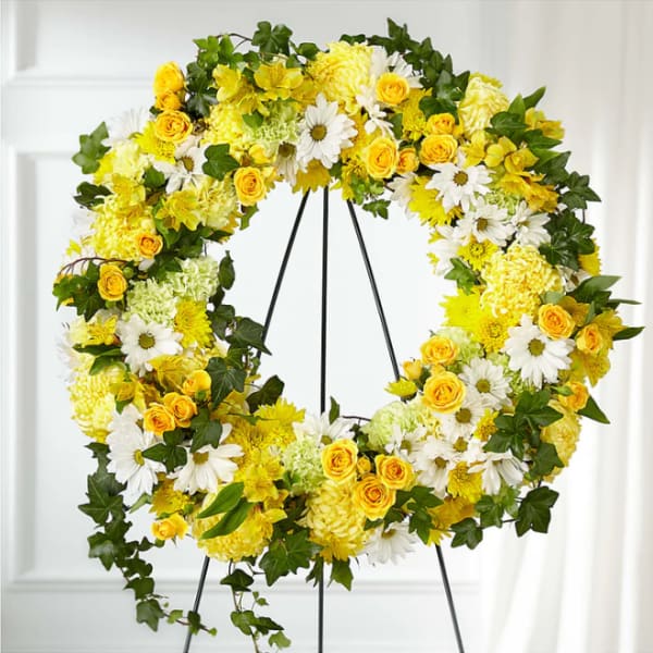 Yellow and white floral wreath on a black stand