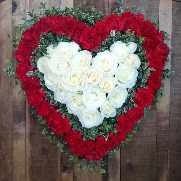Heart-shaped floral arrangement with white roses and red carnations