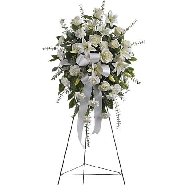 White funeral spray on a standing easel with ribbon