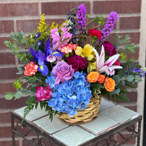 Colorful mixed flower arrangement in a woven basket