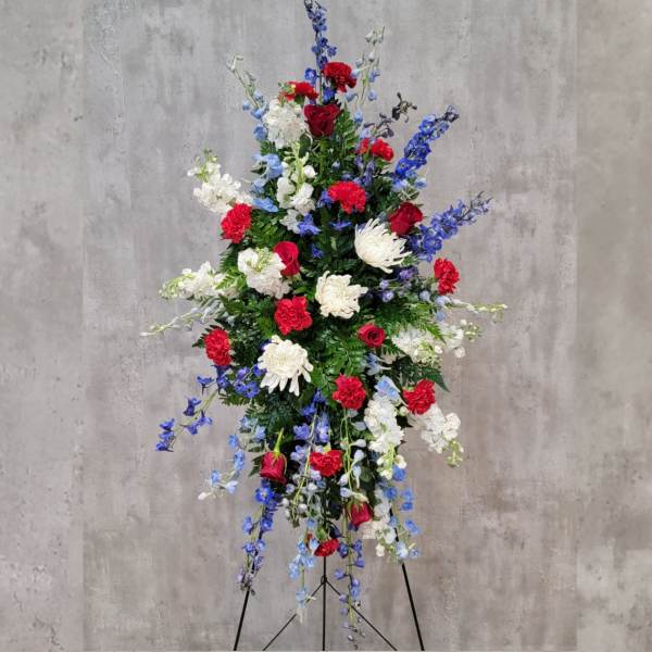Tall standing floral spray with red, white, and blue flowers