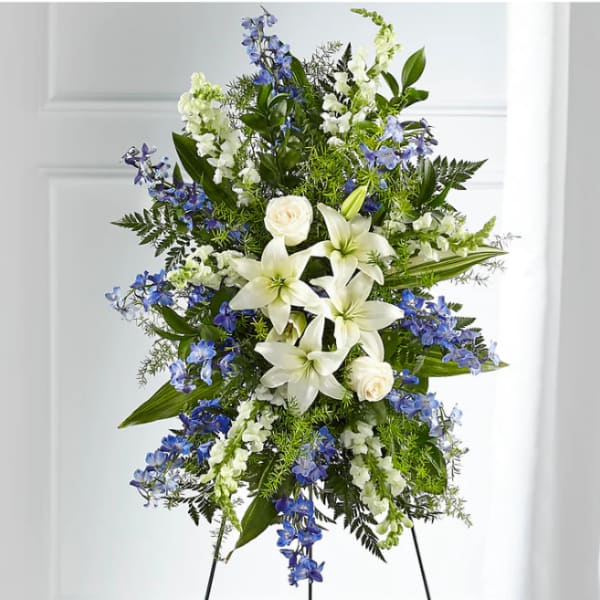 Standing floral spray with white lilies, roses, and blue flowers