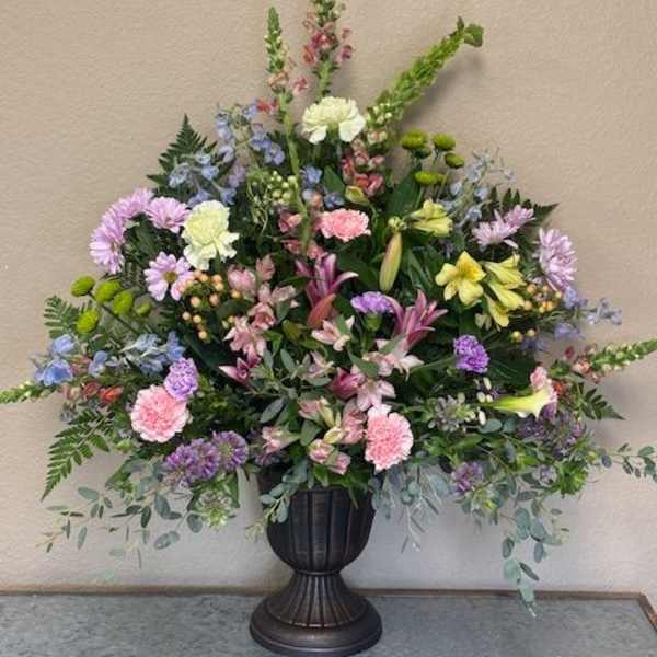 Large mixed floral arrangement in a dark urn vase