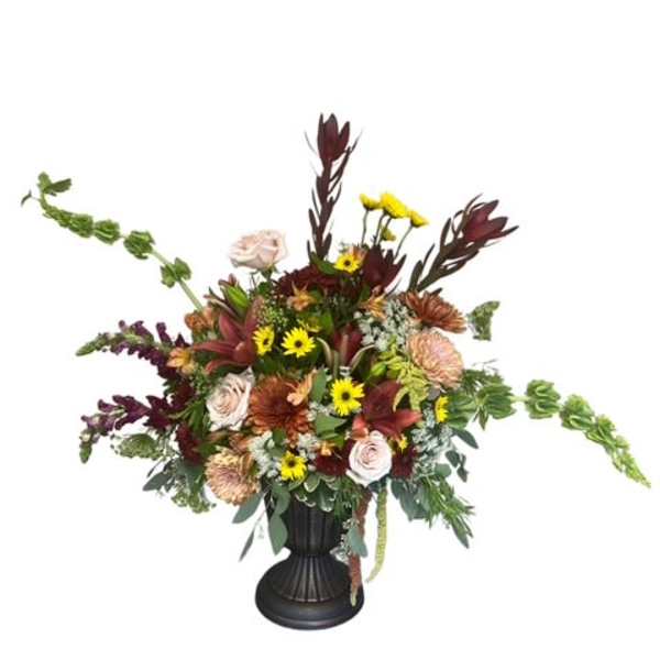 Large mixed flower arrangement in a black vase with burgundy and yellow blooms