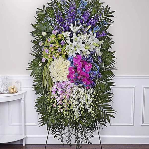 Tall standing floral spray with white lilies, orchids, and purple flowers