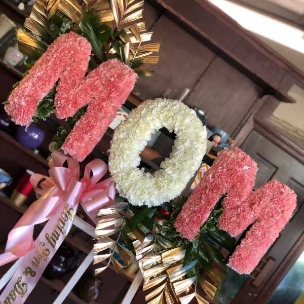 Pink and white floral standing arrangement with a ribbon bow