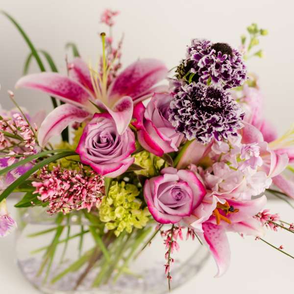 Pink and lavender floral arrangement in a clear glass vase