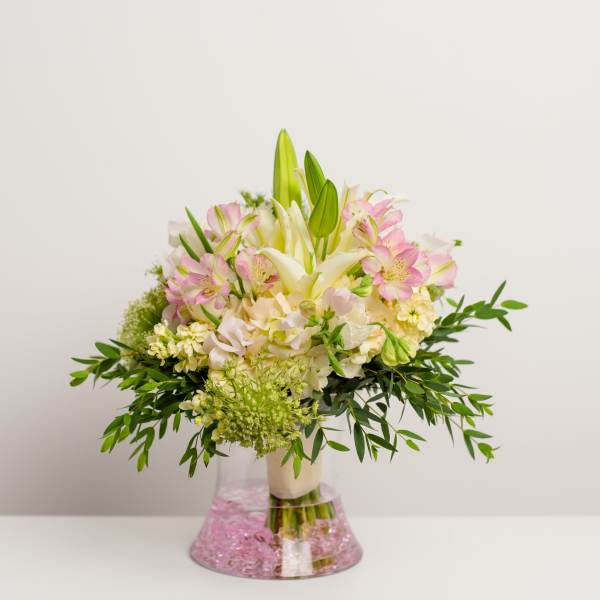 Pink and white bouquet with lilies in a clear vase