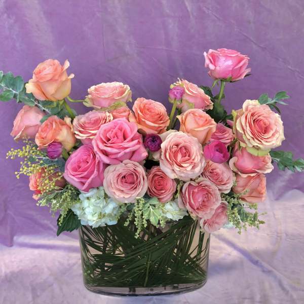 Pink and peach roses arranged in a clear glass vase