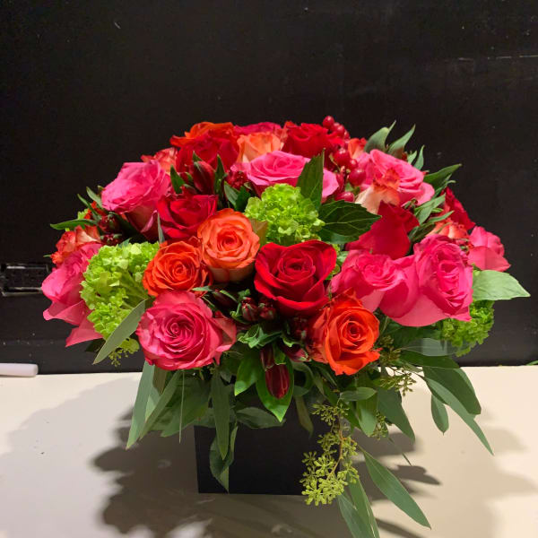 Bouquet of pink, red, and orange roses in a black box
