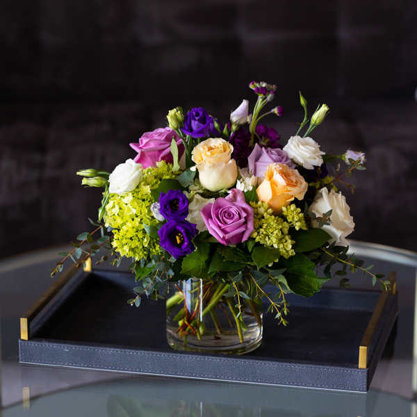 Mixed bouquet of roses and lisianthus in a glass vase