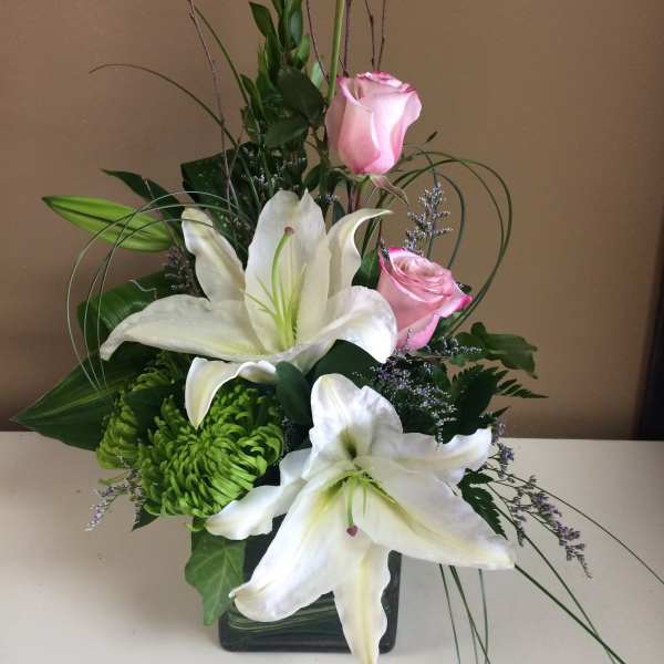 Pink roses and white lilies in a glass vase