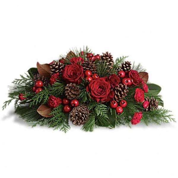 Low holiday centerpiece with red roses, pinecones, and evergreen accents