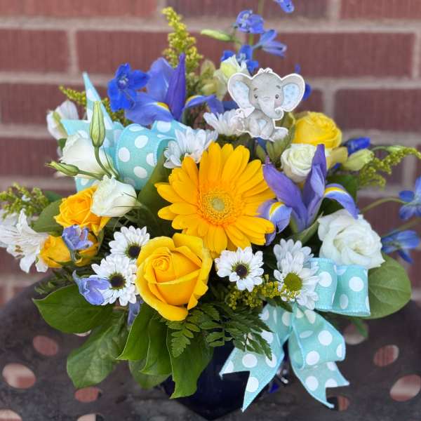 Yellow and white bouquet with blue flowers and a baby elephant pick