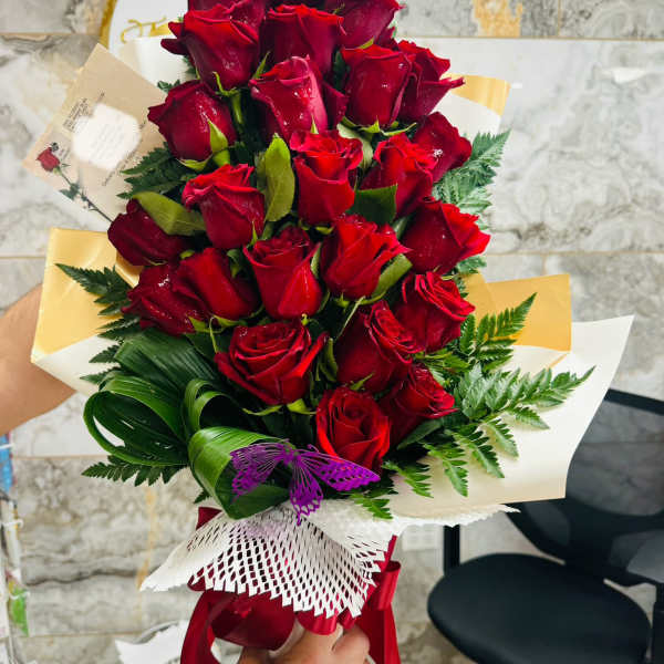 Bouquet of red roses wrapped with white and gold paper