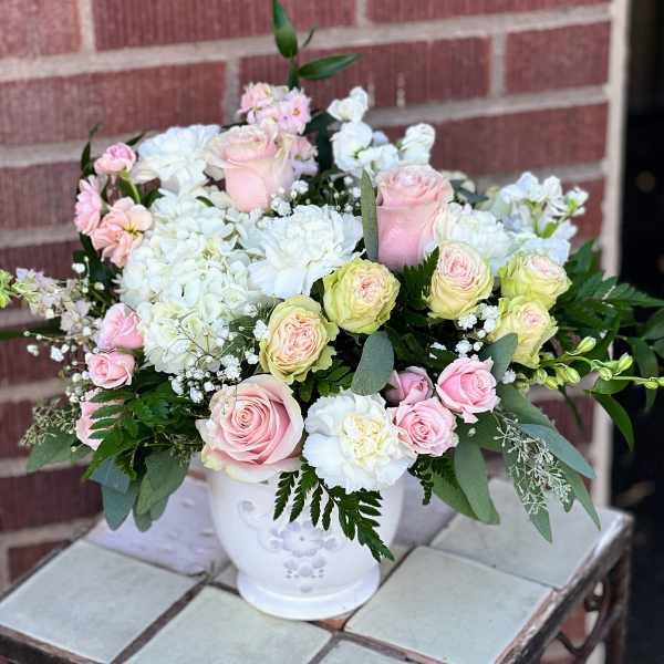 Pink and white rose bouquet in a white ceramic vase