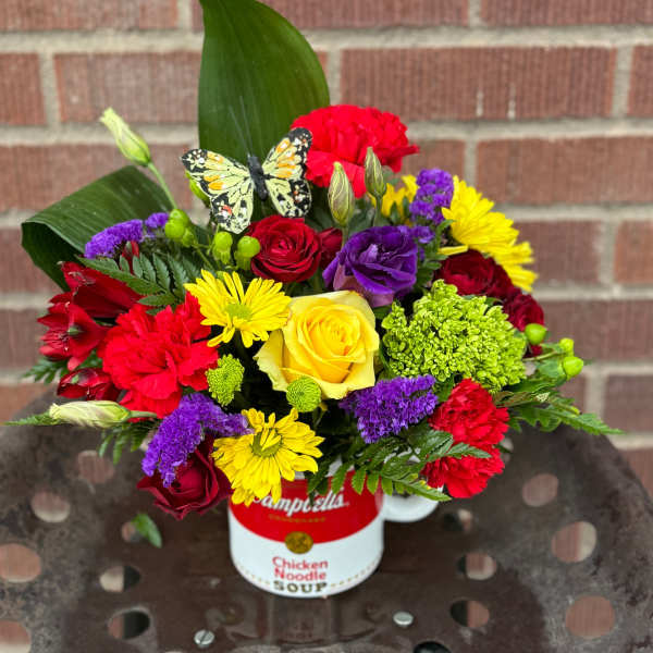 Colorful mixed bouquet in a soup can with a butterfly decoration