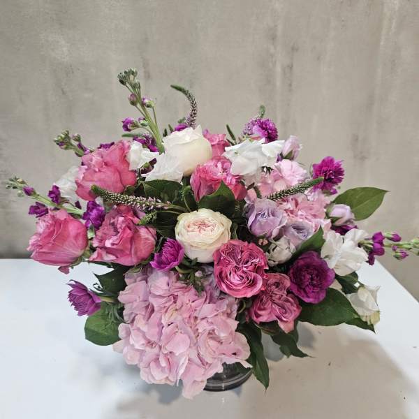 Pink and white rose bouquet with hydrangea in a glass vase
