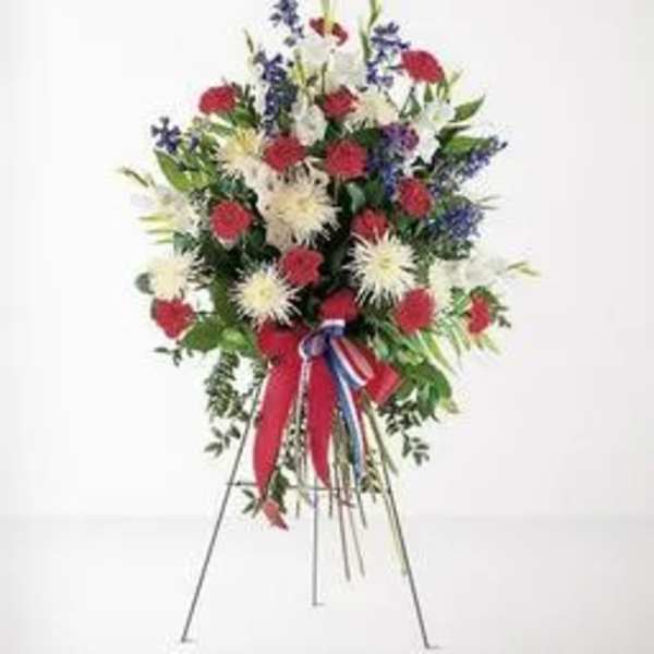 Standing floral spray with red, white, and blue flowers on an easel