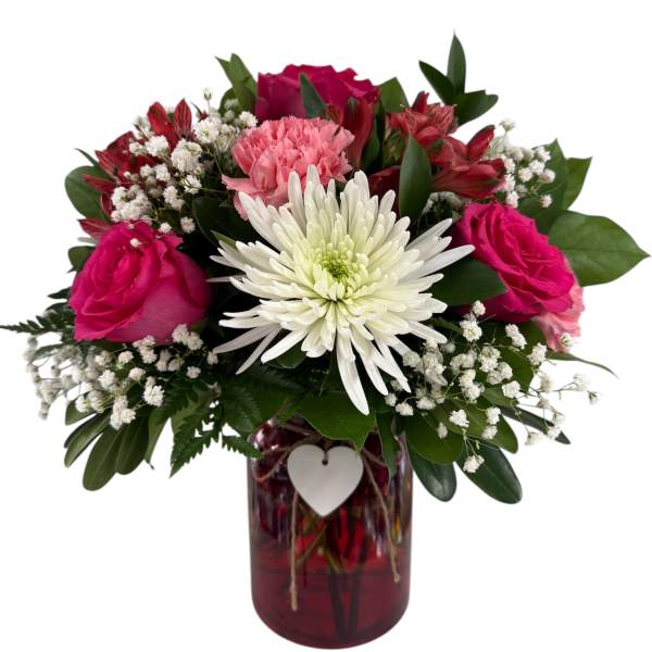 Pink and white flowers arranged in a red glass vase