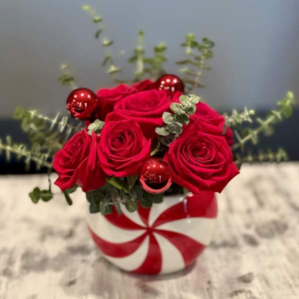 Red roses in a striped round vase with red ornaments