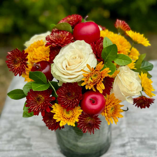 Bouquet of white roses and red-yellow chrysanthemums in a glass vase
