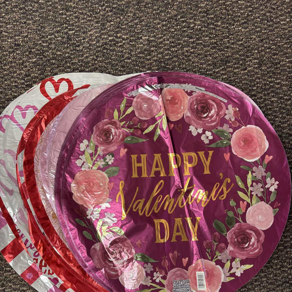 Stack of round foil balloons with Valentine’s Day floral designs