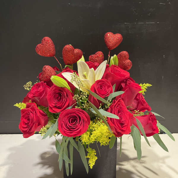 Red roses and white lilies in a black box with glitter heart picks